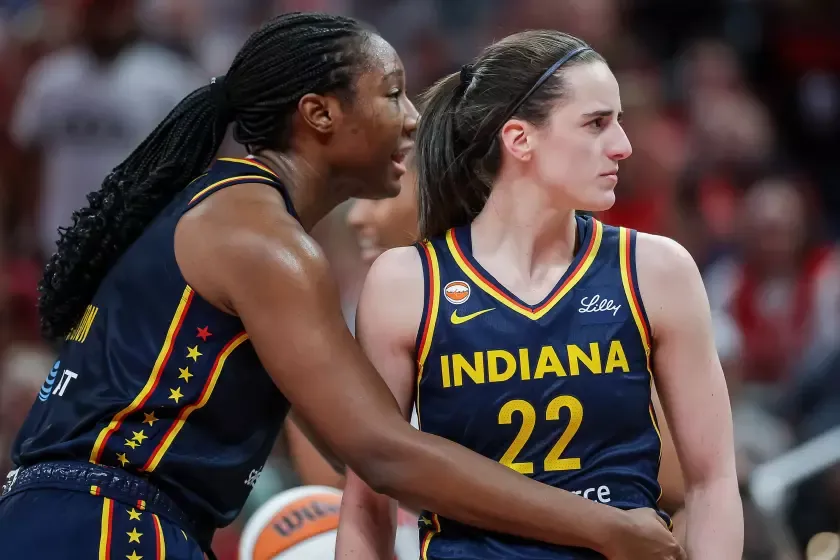 Aliyah Boston #7 holds Caitlin Clark #22 of the Indiana Fever