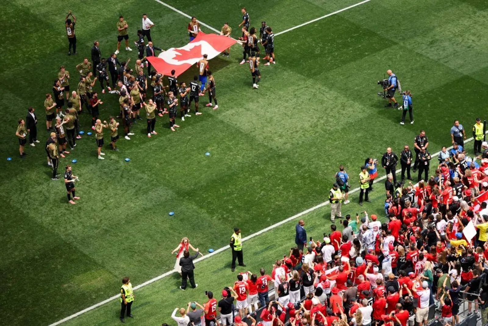 Players of Canada celebrate with the fans after the team's victory and their side's progression to the round of 16.