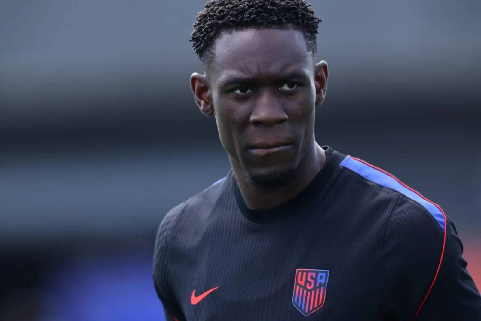 A head and shoulders image of Folarin Balogun, wearing the USA's training kit in front of a blurred background
