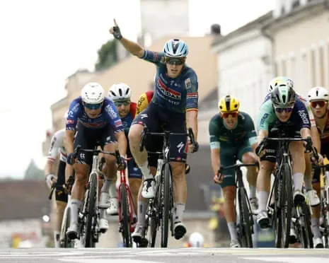 Tim Merlier raises a finger in victory at the line on stage 12