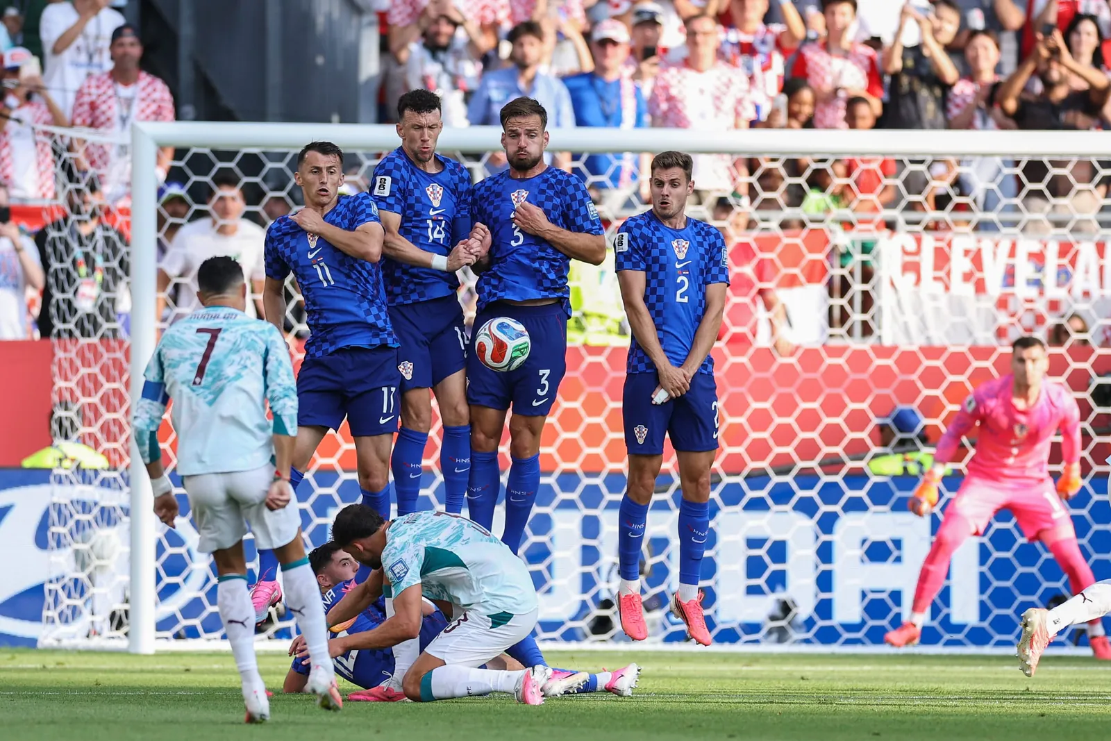Ante Budimir #11, Ivan Perisic #14, Marin Pongracic #3, and Josip Stanisic #2 of Croatia block a free kick from Cristiano Ronaldo #7 of Portugal.