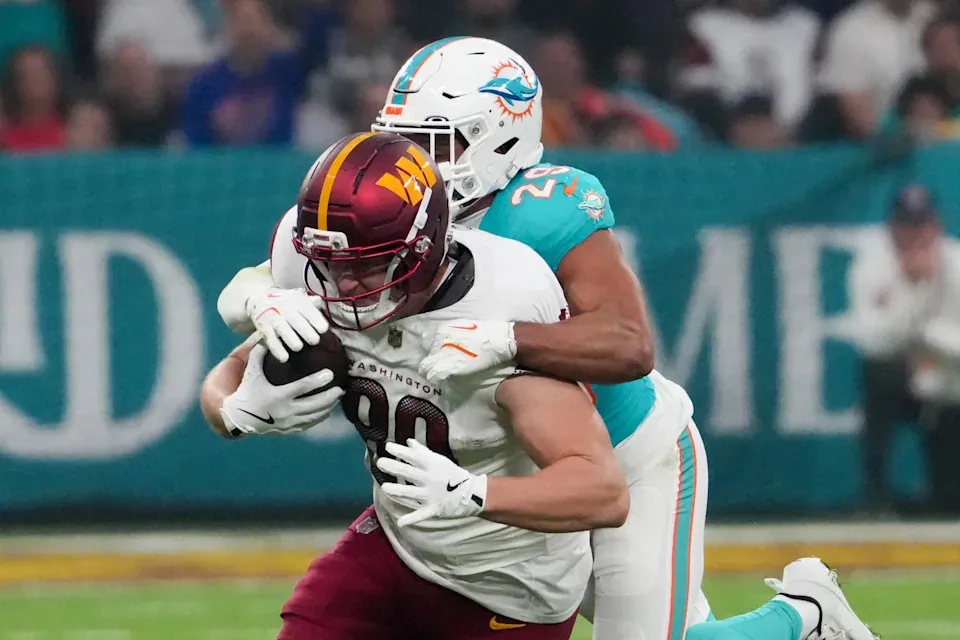 Nov 16, 2025; Madrid, Spain; Washington Commanders tight end Colson Yankoff (80) carries the ball defended by Miami Dolphins safety Minkah Fitzpatrick (29) in the first quarterduring the 2025 NFL Madrid Game at Santiago Bernabeu Stadium. Mandatory Credit: Kirby Lee-Imagn Images
