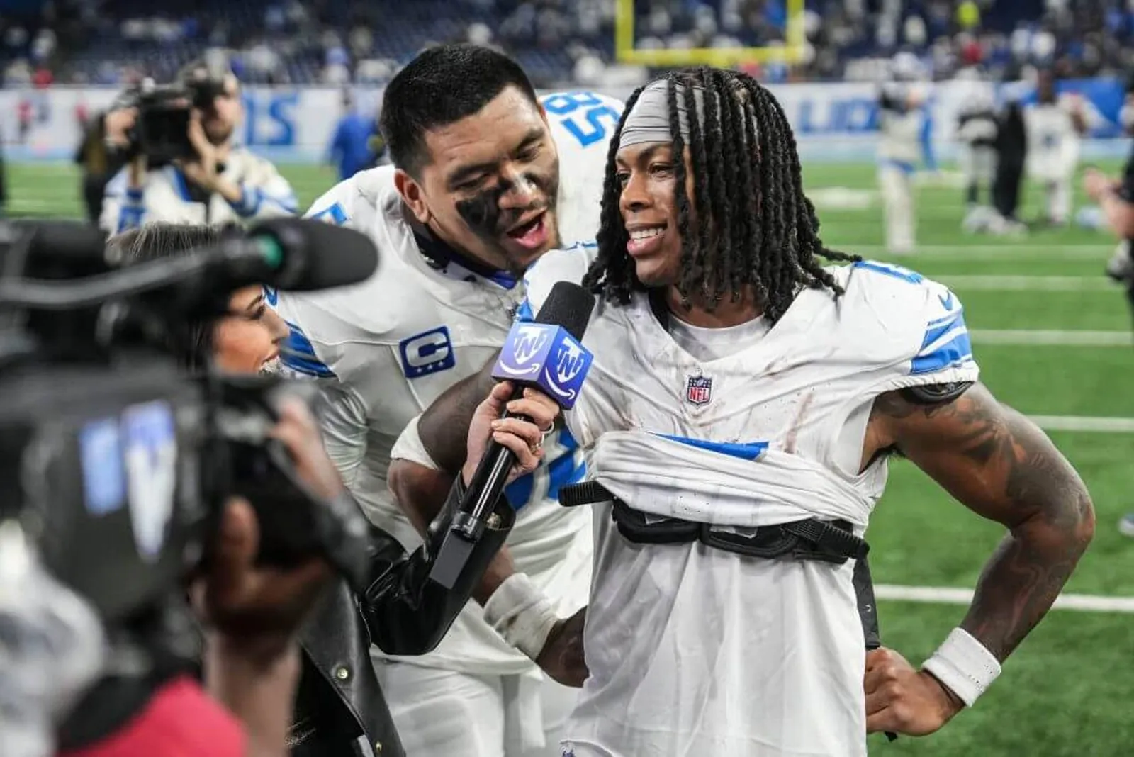 Detroit Lions offensive tackle Penei Sewell (58) interrupts as running back Jahmyr Gibbs (0) is being interviewed after 44-30 win over Dallas Cowboys at Ford Field in Detroit on Thursday, Dec. 4, 2025.