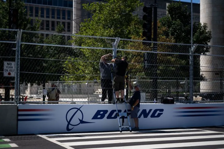 Workers continue setting up ahead of the Freedom 250 Grand Prix on the National Mall in Washington, DC, on August 19, 2026.